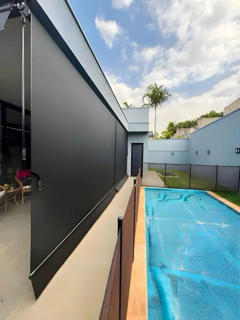 Toldo vertical instalado junto a una alberca